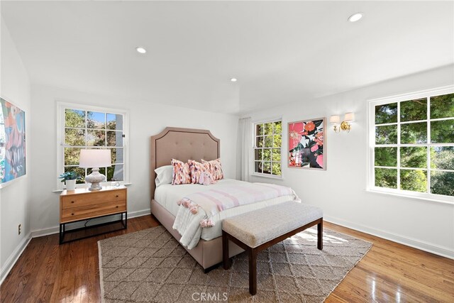 bedroom with multiple windows, wood finished floors, and recessed lighting