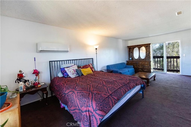 bedroom featuring carpet flooring, a textured ceiling, a wall unit AC, and access to outside