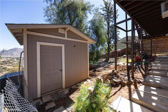 view of shed with a mountain view and fence