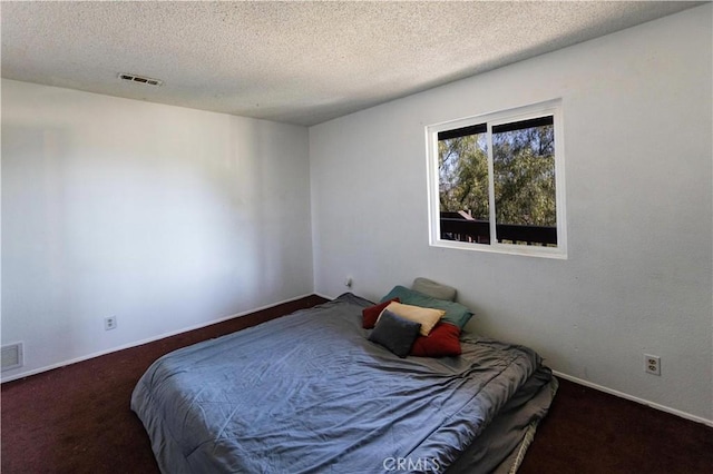 bedroom with baseboards, visible vents, carpet floors, and a textured ceiling