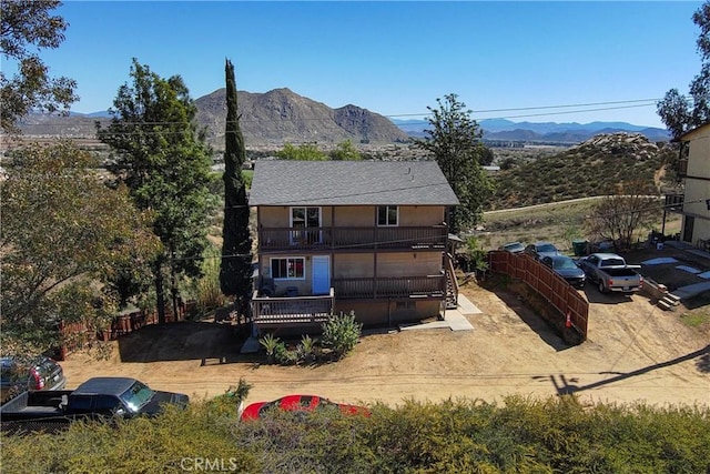 back of house featuring a mountain view and a balcony