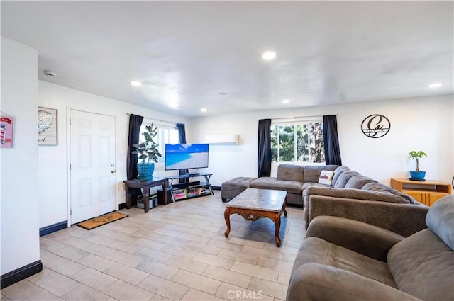 living room featuring recessed lighting, baseboards, and an AC wall unit