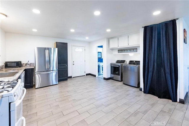 kitchen with recessed lighting, washer and dryer, freestanding refrigerator, and black microwave