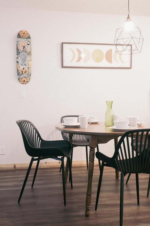 dining area featuring baseboards and dark wood-style floors