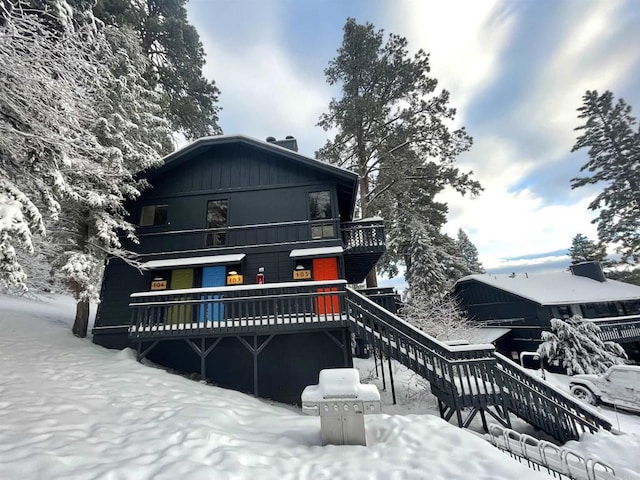 snow covered property featuring stairs