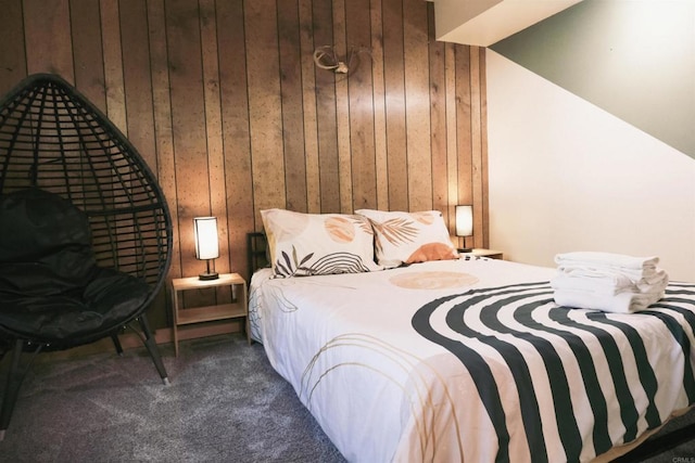 carpeted bedroom featuring wood walls