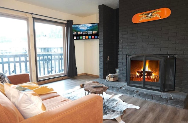 living room with plenty of natural light, a fireplace, and wood finished floors