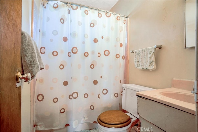 bathroom featuring vanity, a shower with shower curtain, and toilet