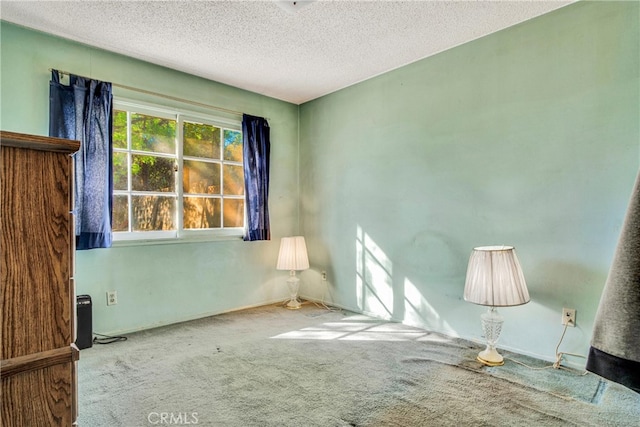 empty room featuring baseboards, carpet floors, and a textured ceiling