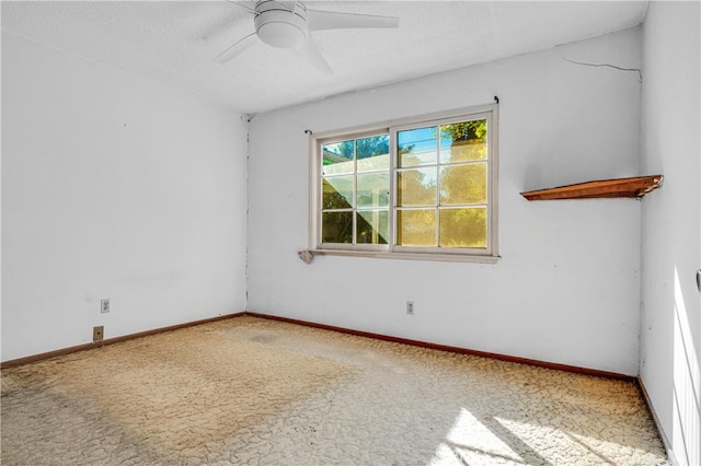 carpeted spare room featuring baseboards, a textured ceiling, and ceiling fan