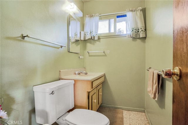 half bath featuring baseboards, toilet, and vanity