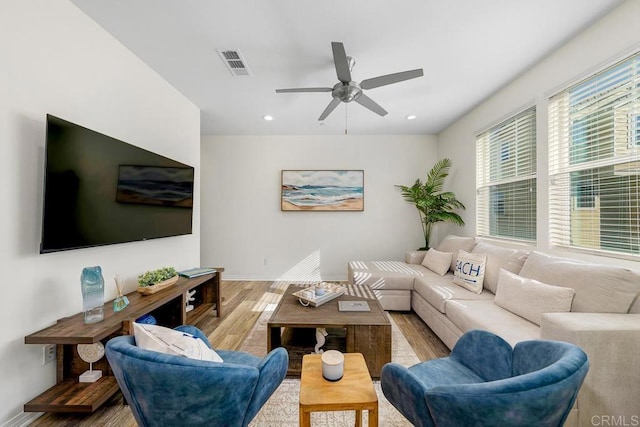 living room featuring visible vents, baseboards, ceiling fan, recessed lighting, and wood finished floors