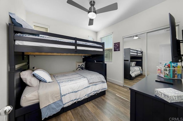 bedroom featuring ceiling fan, a closet, baseboards, and wood finished floors