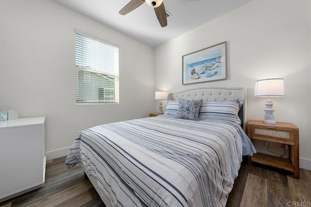 bedroom featuring baseboards, wood finished floors, and a ceiling fan