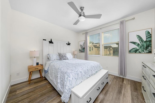 bedroom with dark wood-type flooring, a ceiling fan, and baseboards