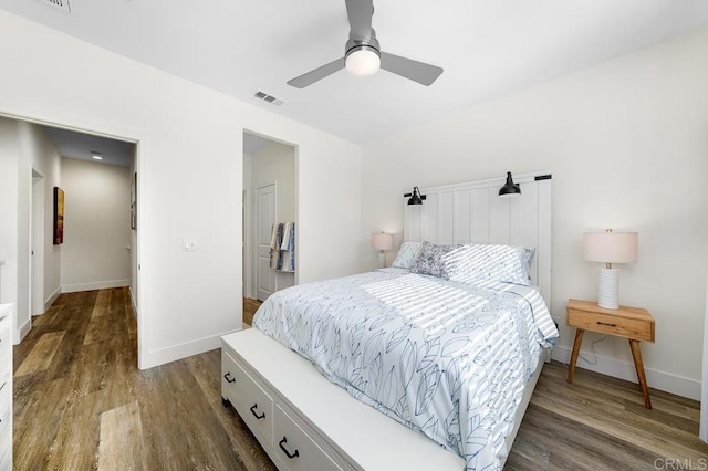 bedroom with visible vents, baseboards, ceiling fan, and dark wood-style flooring