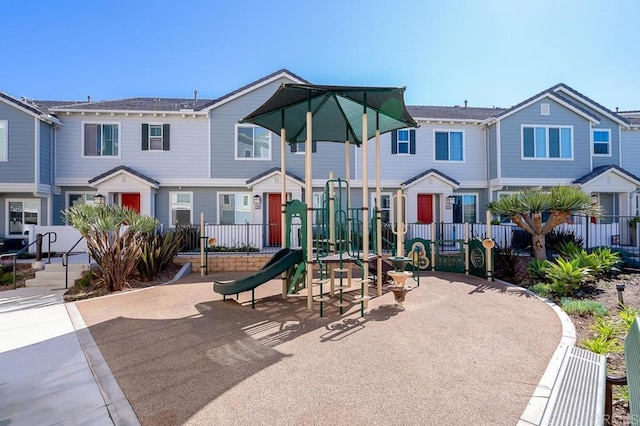 view of jungle gym featuring a residential view and fence