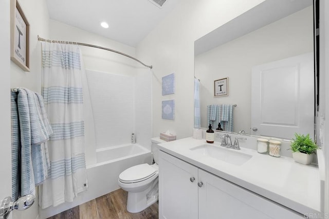 full bathroom featuring vanity, toilet, wood finished floors, and shower / bath combo with shower curtain