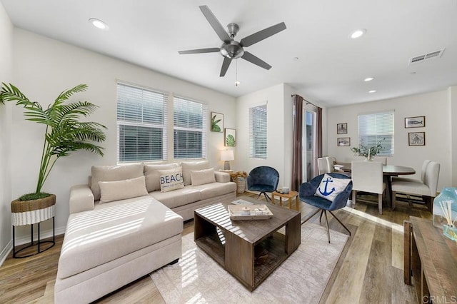 living room with visible vents, recessed lighting, light wood-type flooring, and a ceiling fan