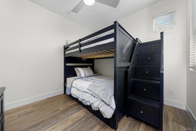 bedroom with baseboards, wood finished floors, and a ceiling fan