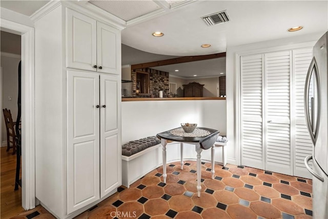 kitchen featuring white cabinetry, recessed lighting, visible vents, and freestanding refrigerator