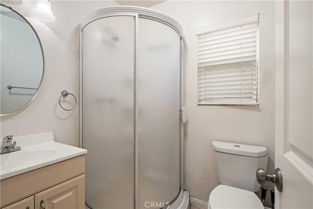 full bathroom featuring a stall shower, toilet, and vanity