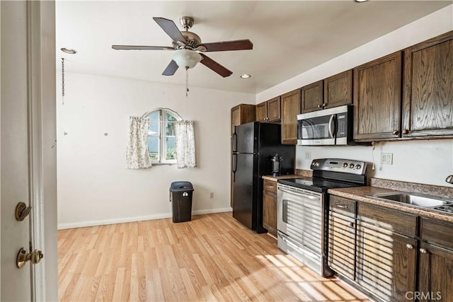 kitchen featuring dark brown cabinets, appliances with stainless steel finishes, light wood-style floors, a ceiling fan, and a sink