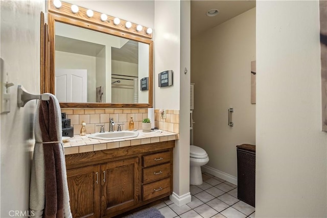 full bath featuring toilet, backsplash, tile patterned flooring, baseboards, and vanity