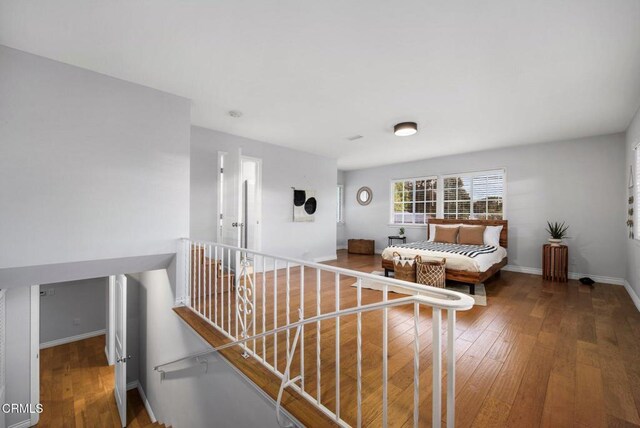 interior space with hardwood / wood-style flooring, an upstairs landing, and baseboards