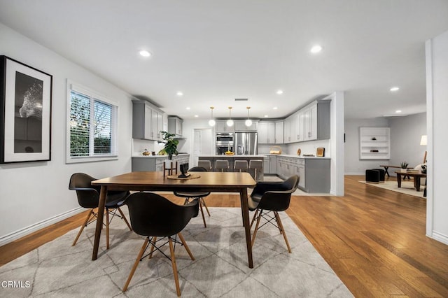 dining area featuring recessed lighting, light wood-type flooring, and baseboards