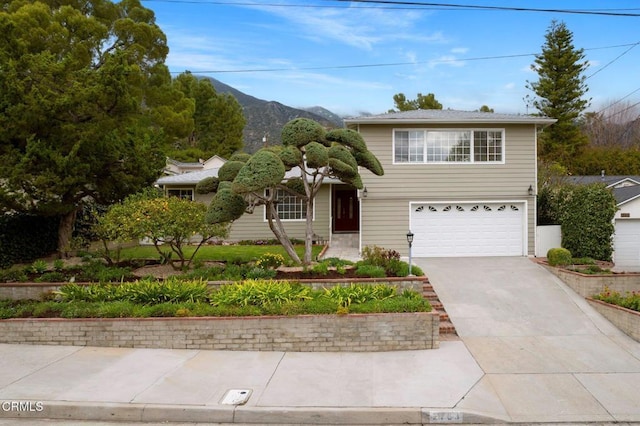 traditional-style house with concrete driveway, a mountain view, and a garage