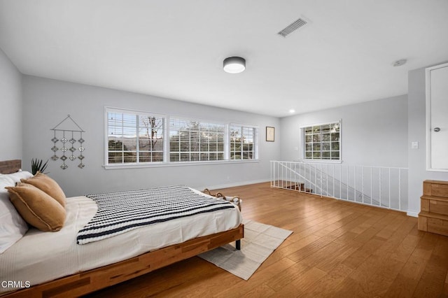 bedroom featuring visible vents, baseboards, and hardwood / wood-style flooring