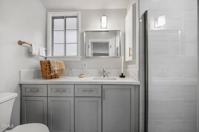 bathroom featuring toilet, a stall shower, and vanity