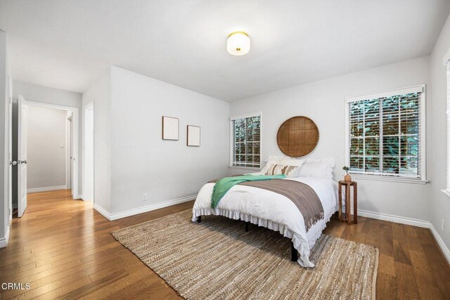 bedroom with baseboards and hardwood / wood-style flooring