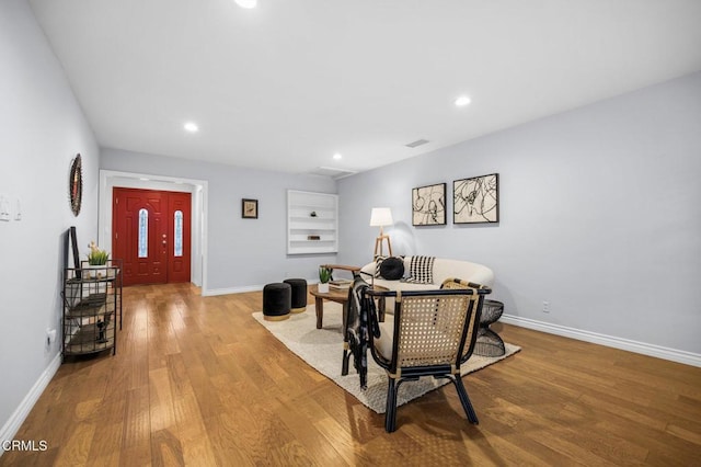 living room featuring recessed lighting, visible vents, baseboards, and wood finished floors