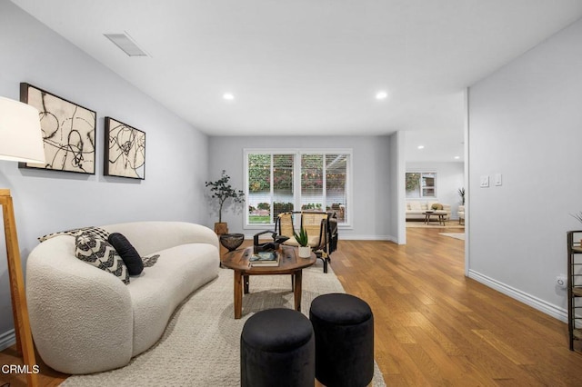 living room featuring recessed lighting, wood finished floors, visible vents, and baseboards