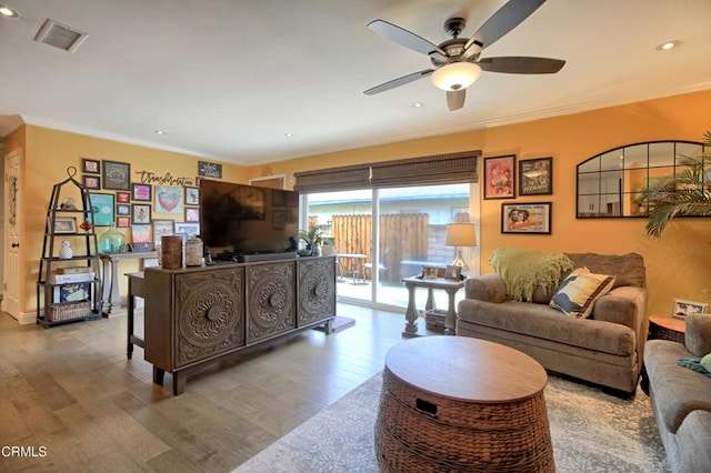 living room featuring crown molding, wood finished floors, visible vents, and ceiling fan