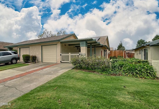 view of front of house with stucco siding, an attached garage, a front yard, and fence