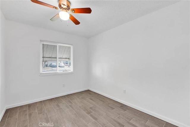 spare room featuring baseboards, ceiling fan, and light wood finished floors