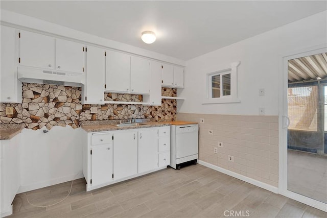 kitchen featuring open shelves, under cabinet range hood, white dishwasher, white cabinetry, and a sink