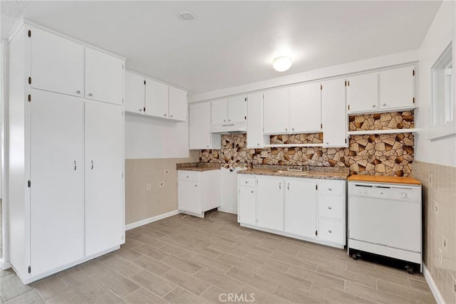 kitchen featuring a sink, tile walls, dishwasher, and white cabinetry