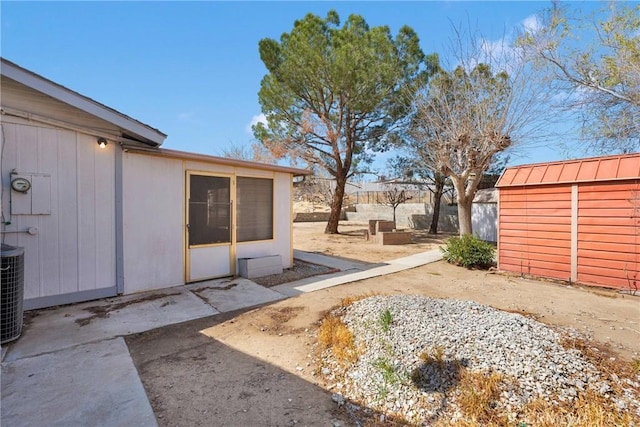 view of yard with an outdoor structure, fence, a shed, and a patio