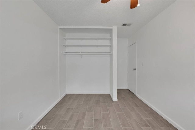 unfurnished bedroom with visible vents, baseboards, wood finished floors, a closet, and a textured ceiling