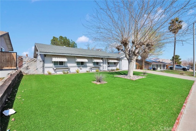 ranch-style home featuring concrete driveway, a garage, fence, and a front yard