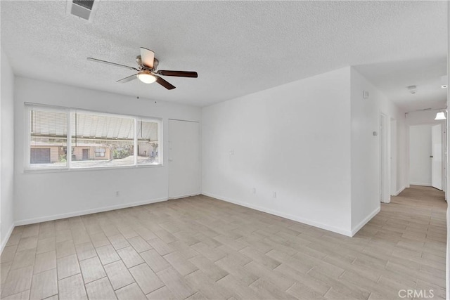 empty room featuring visible vents, a textured ceiling, light wood finished floors, baseboards, and ceiling fan