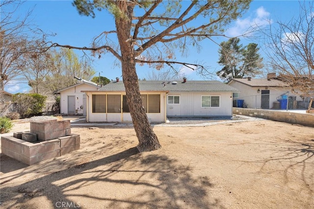 rear view of house featuring fence and a sunroom