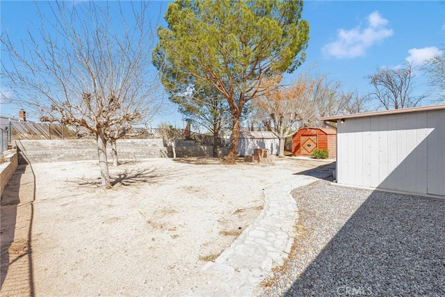 view of yard featuring an outbuilding, a storage shed, and a fenced backyard