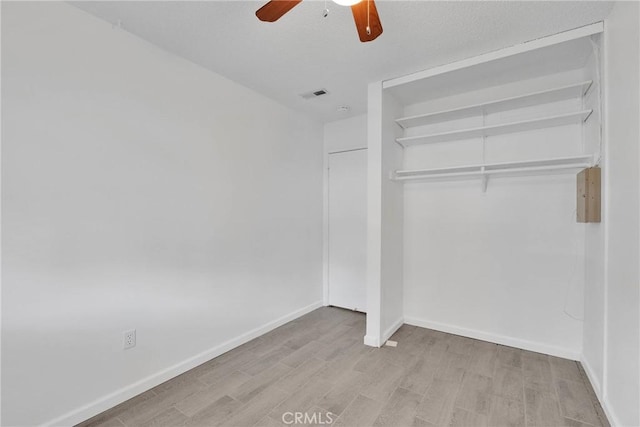 unfurnished bedroom featuring visible vents, a ceiling fan, wood finished floors, a closet, and baseboards