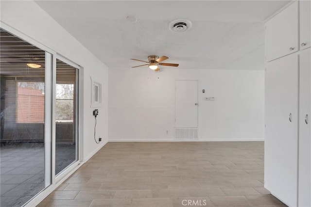 empty room featuring visible vents, baseboards, and a ceiling fan