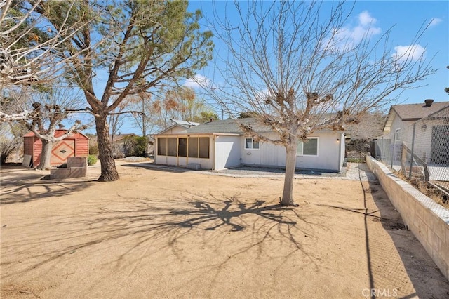 exterior space featuring fence and a sunroom